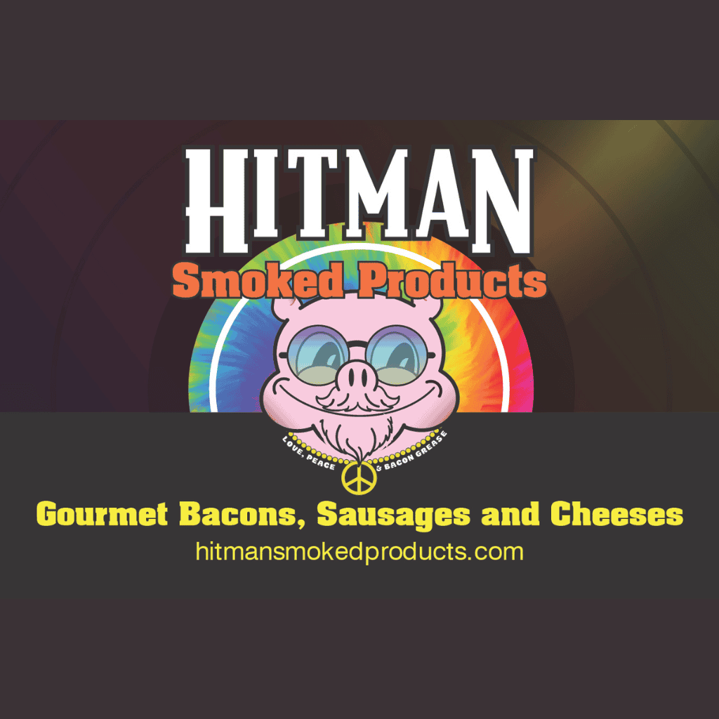 Logo for Hitman Smoked Products featuring a smiling pig with glasses, a peace sign, and a rainbow background. Text advertises Gourmet Bacons, Sausages and Cheeses and includes the website hitmansmokedproducts.com.