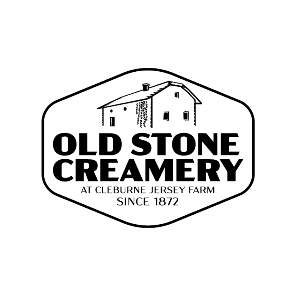 Logo for Old Stone Creamery featuring a simple illustration of a barn and text: OLD STONE CREAMERY at Cleburne Jersey Farm since 1872 inside a rounded hexagonal border.