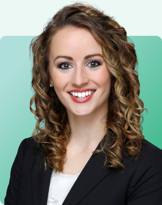 A woman with curly light brown hair, wearing a black blazer and white top, smiles at the camera in front of a light green gradient background.