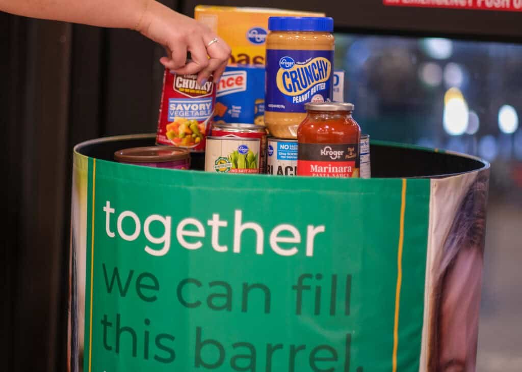 Donation bin at a Kroger store filled with canned goods, pasta sauce, and peanut butter for Second Harvest’s food drive, part of Kroger’s support for fighting hunger.