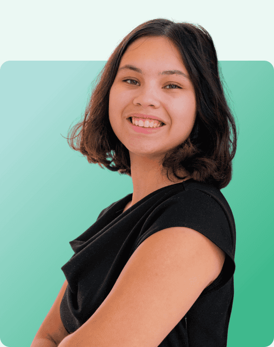 Smiling young person with medium-length dark hair and a black top stands with arms crossed against a green gradient background with rounded corners.