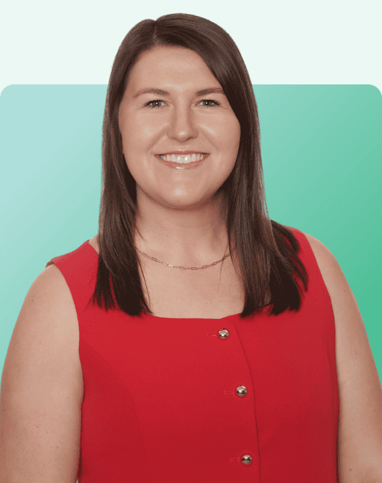A woman with straight brown hair, wearing a sleeveless red dress with gold buttons, smiles at the camera against a teal gradient background.